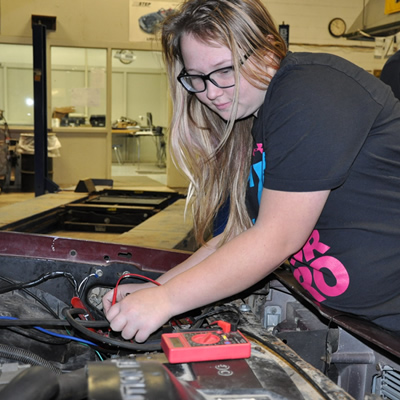 Student working on car engine